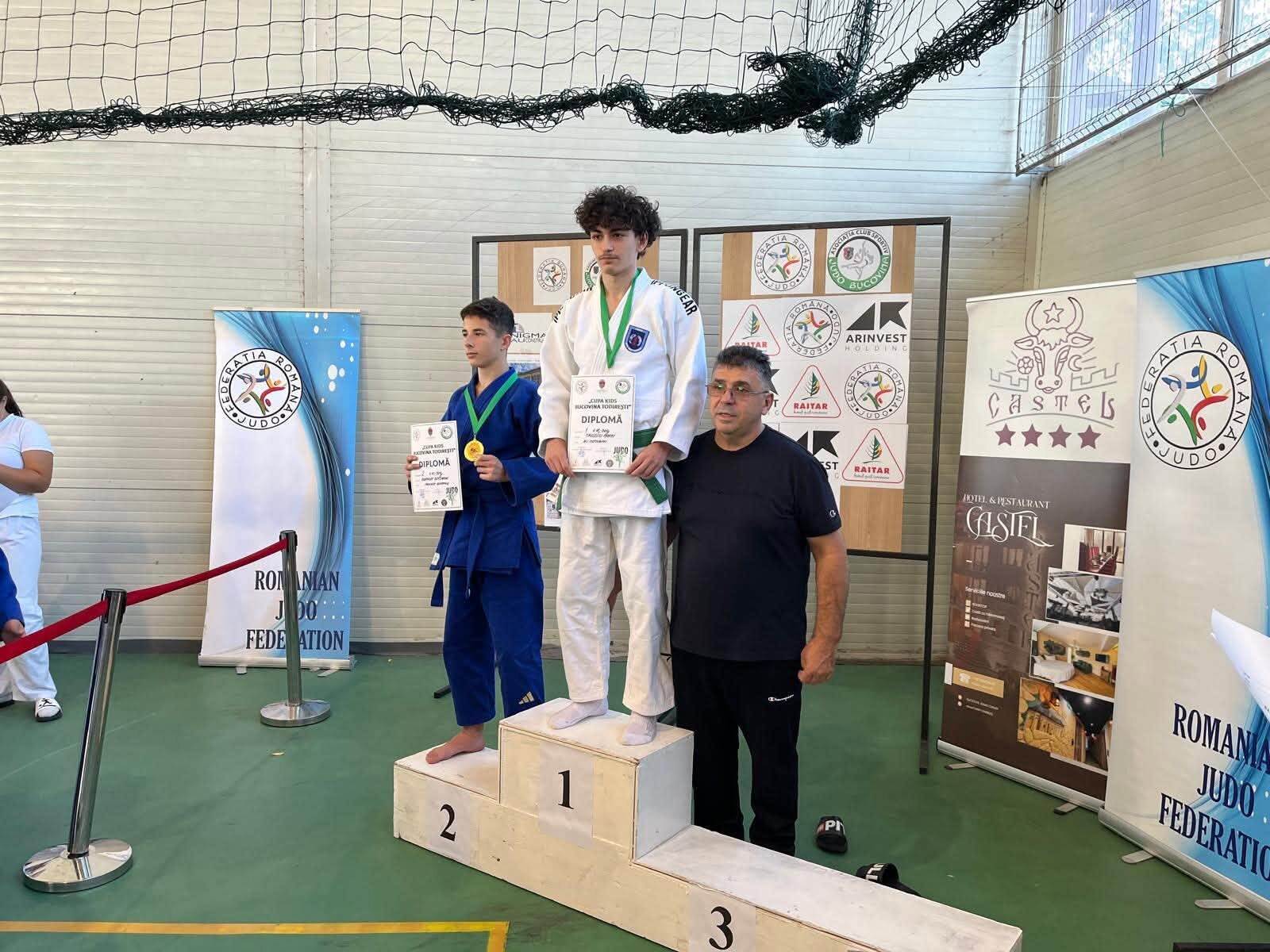 Sportivi tineri pe podium cu medalii și diplome, alături de un adult